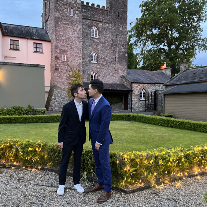 Tyler and Justin leaning in for a kiss at an Irish castle